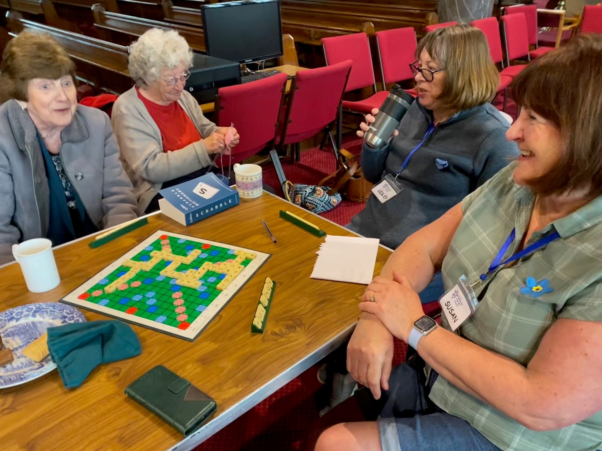 Four people playing Scrabble